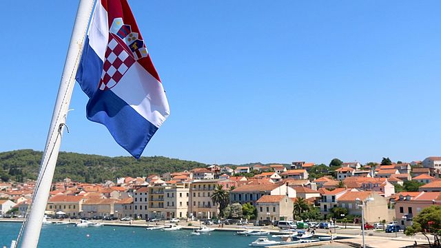 Die kroatische Fahne weht in einem Badeort im Hintergrund.