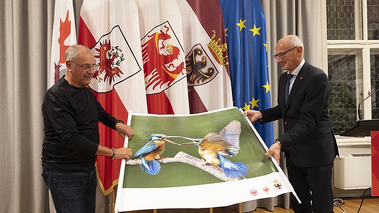 © Land Tirol/Sedlak Enthüllung des Titelfotos: (von links) Fotograf Fernando Tait und der Euregio-Präsident, Tirols Landeshauptmann Anton Mattle.