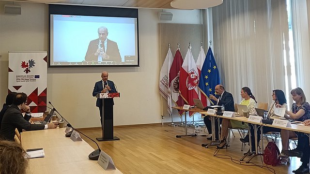 © Euregio Ein Vortragender der Veranstaltung steht am Rednerpult in der Vertretung.