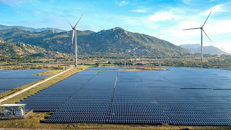 Luftaufnahme eines Wind- und Solarparks vor dem Hintergrund einer Berglandschaft