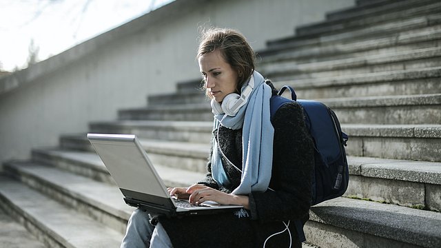 Junge Frau arbeitet an einem Laptop.