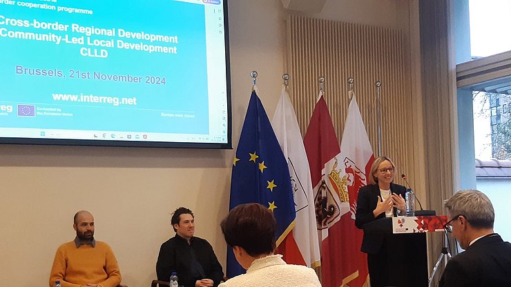 At the podium, South Tyrolean Councillor Magdalena Amhof speaks to the room.