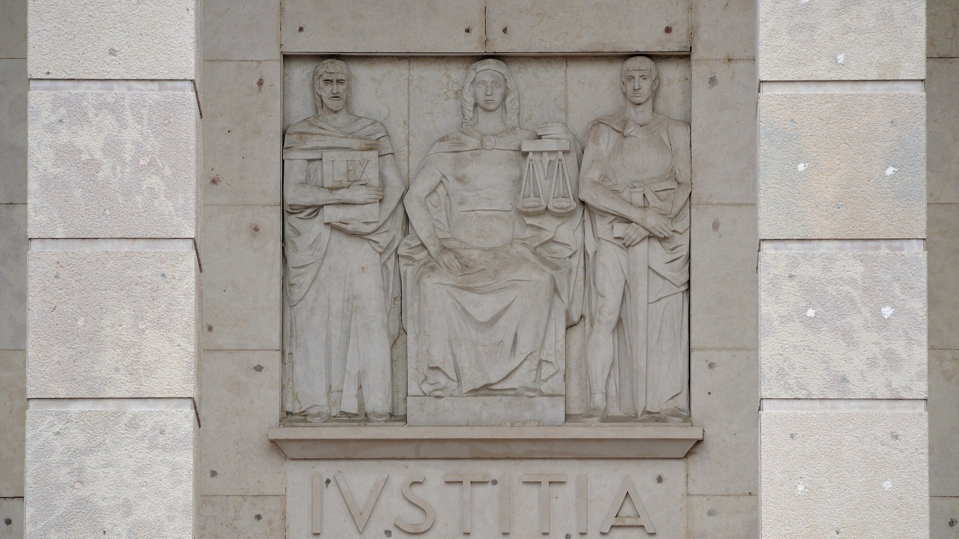 Rilievo della Iustitia seduta sull’edificio del Tribunale di Bolzano, costruito a partire dal 1939. Degna di nota la mancanza della benda sugli occhi, l’attributo comunemente associato all’imparzialità.