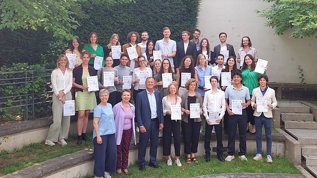 Gruppenbild mit den Zertifikaten der Euregio Brussels School im Garten der Vertretung.