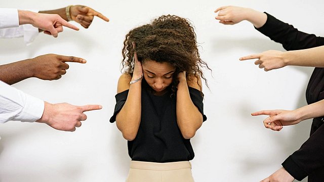 Viele Menschen, die auf eine Frau zeigen, als Zeichen der Diskriminierung