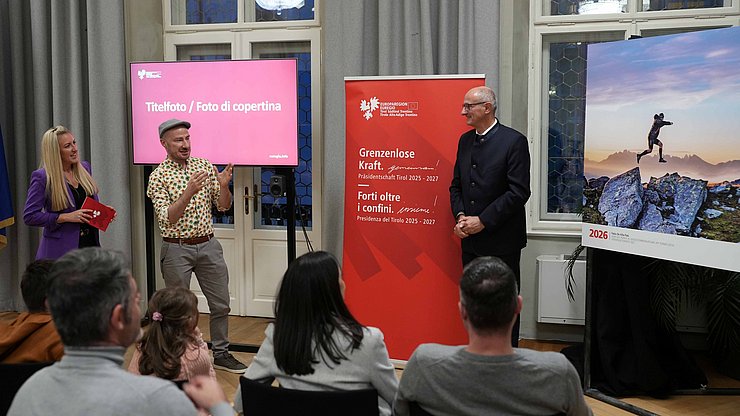 © LandTirol/DanijelJovanovic Nach der Enthüllung des Titelfotos: (von links) Moderatorin Karin Gschnitzer, Fotograf Fabio De Villa Palù und Euregio-Präsident, Tirols Landeshauptmann Anton Mattle.