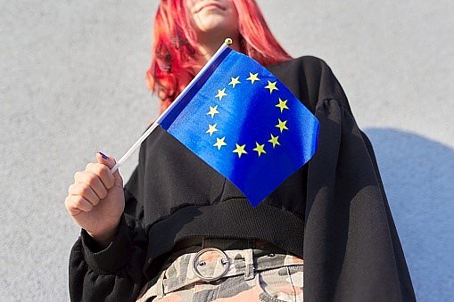 Ragazza che tiene in mano una bandierina dell’Unione Europea.