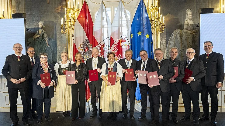 LH Mattle und Südtirols LH Kompatscher mit den elf TirolerInnen und SüdtirolerInnen, die 2026 das Ehrenzeichen des Landes Tirol erhalten haben.