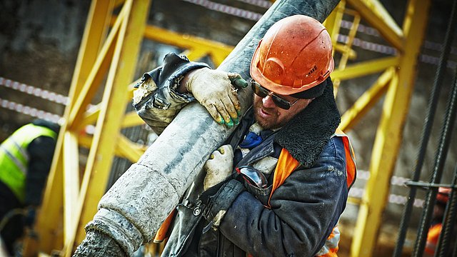 Operaio che getta una lastra di cemento in un cantiere.