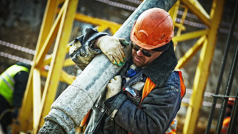 Operaio che getta una lastra di cemento in un cantiere.