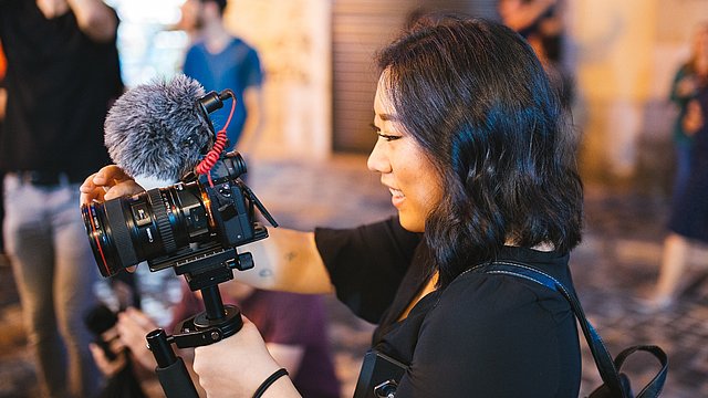 Donna Sorridente Che Tiene Macchina Fotografica Nera Dslr