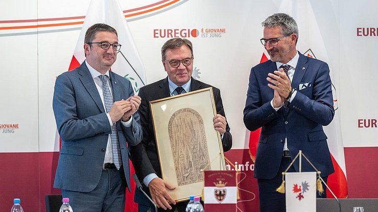 Der scheidende Tiroler Landeshauptmann Günther Platter wird mit einem Nachdruck des Trentiner Künstlers Depero geehrt. Im BIld von links nach rechts: Maurizio Fugatti, Günther Platter und Arno Kompatscher