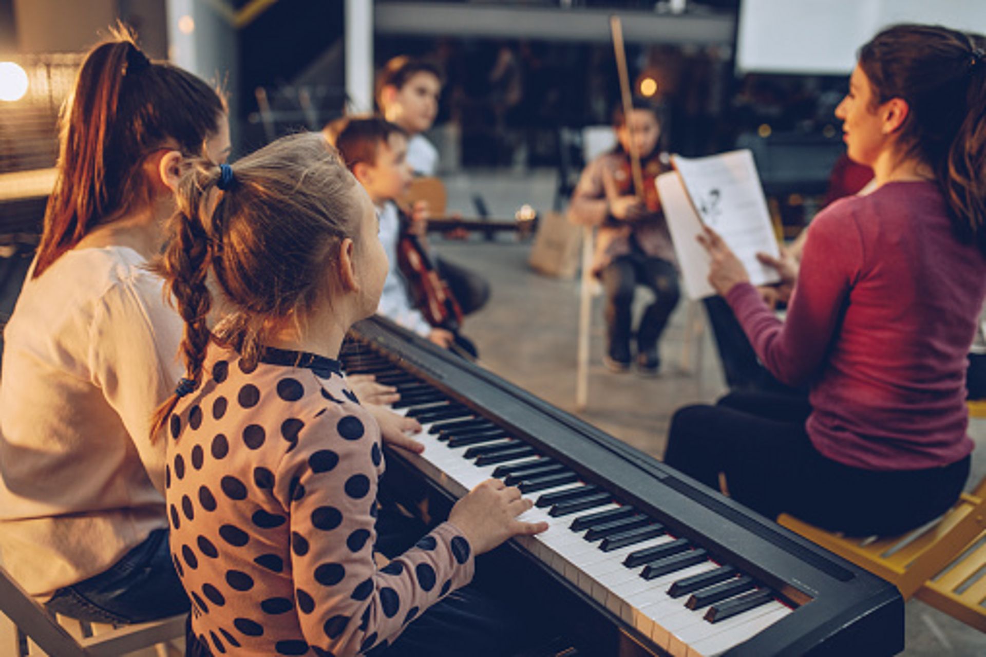 Gruppe von Kindern, die in der Musikschule Instrumente spielen lernen