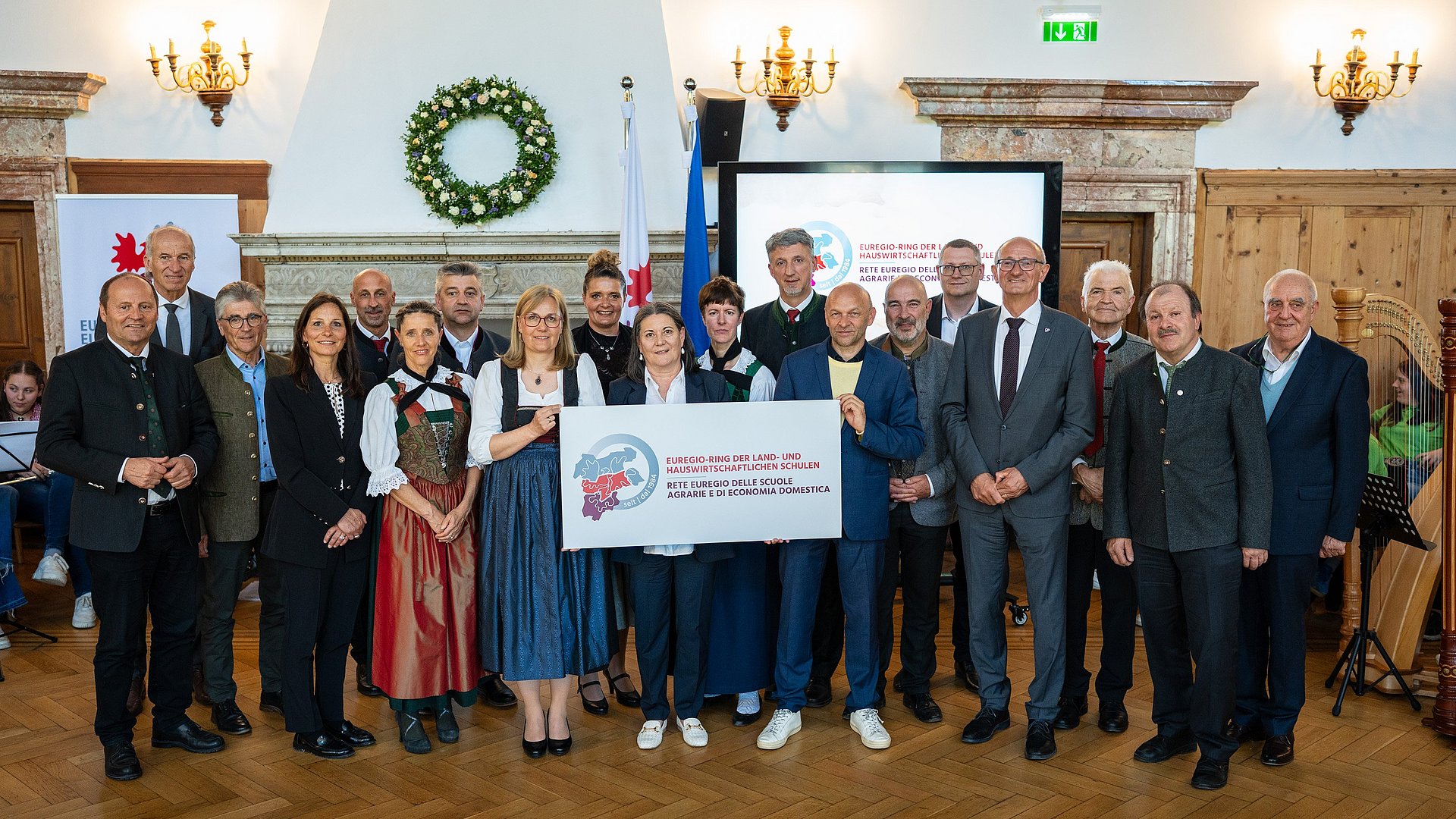Historisches Foto mit Vertretern der Euregio-Politik, Gründungsmitgliedern sowie amtierenden und früheren Schuldirektorinnen und -direktoren.