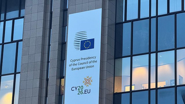 L’immagine mostra l’esterno dell’edificio del Consiglio dell’Unione europea con il logo della Presidenza di Cipro. 