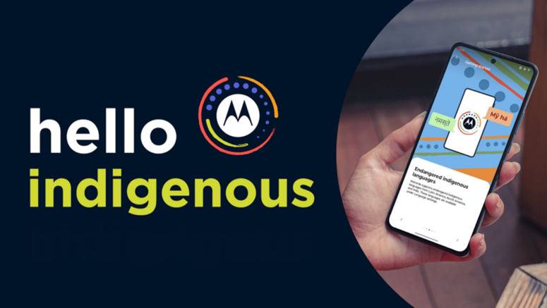 Una mano tiene uno smartphone che mostra l’interfaccia del progetto “Hello Indigenous” di Motorola, dedicato alla digitalizzazione e alla tutela delle lingue indigene e minoritarie.