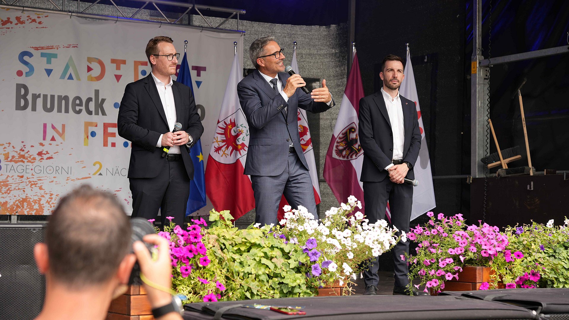 © Euregio/Guido Steinegger Dialogo politico sull'Euregio sul palco della festa a Brunico con (da sinistra) i rappresentanti della Giunta dell'Euregio Philip Wohlgemuth (Tirolo), il presidente dell'Euregio Arno Kompatscher (Alto Adige) e Simone Marchiori (Trentino).