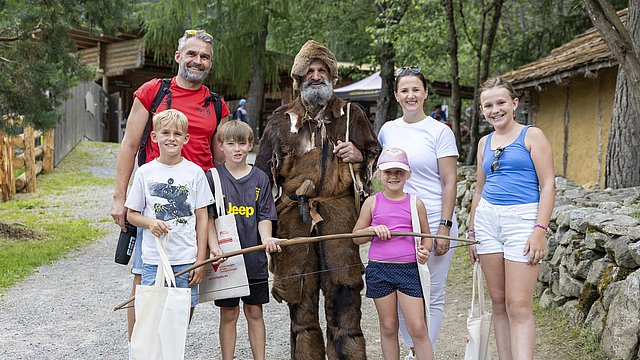 Familienlandesrätin Astrid Mair, "Ötzi-Erich" und eine Familie beim Familienfest.