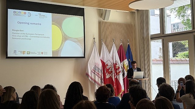 Giorgio Gori, Abgeordneter des Europäischen Parlaments, steht hinter einem Rednerpult und spricht zum Publikum. 