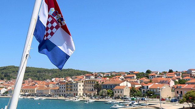 © Shutterstock Die kroatische Fahne weht in einem Badeort im Hintergrund.