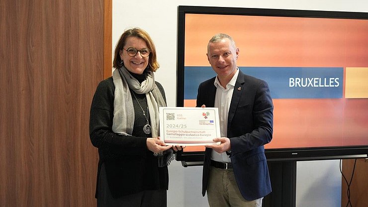 Il segretario generale dell'Euregio, Christoph von Ach, consegna la targa alla dirigente dell'Istituto di Istruzione Secondaria Superiore Galileo Galilei, Paola Burzacca
