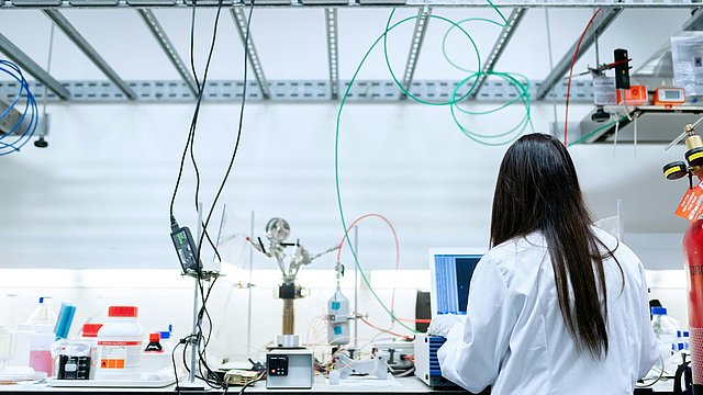 Uno scienziato si trova in un laboratorio e guarda uno schermo.