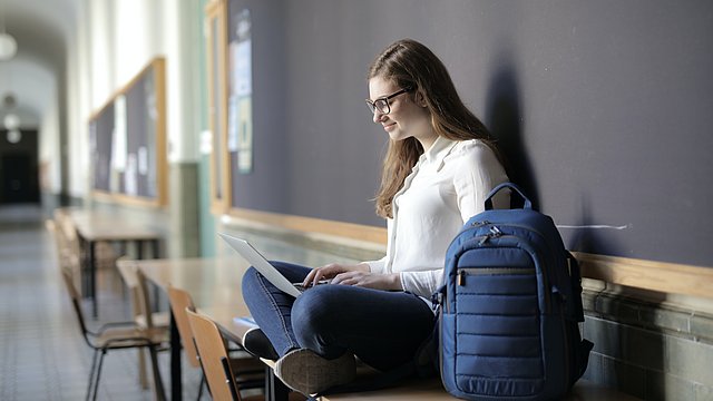 © Pexels/Andrea Piacquadio Donna seduta alla finestra con un computer portatile.