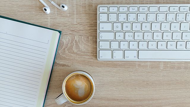 Schreibtisch mit Tastatur und Kaffee