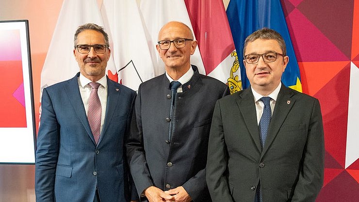 © Land Tirol/Pölzl Bën 30 ani na usc deberieda a Bruxelles, de gra al Ufize de Cunliamënt y de Referimënt dl’Euregio: i presidënc dla Jontes raiuneles de Südtirol, Arno Kompatscher (da man ciancia), l presidënt dl’Euregio Anton Mattle (Tirol) y Maurizio Fugatti (Trentin) pra la festa ufiziela ai 18 de nuvëmber 2025.