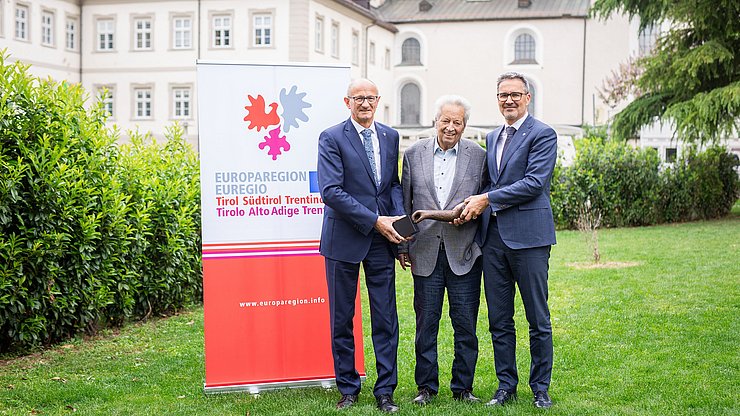 Il Capitano del Tirolo Anton Mattle (a sx) e il Presidente della Provincia autonoma di Bolzano Arno Kompatscher (a dx) insieme a Wendelin Weingartner, già Capitano del Tirolo, con in mano il premio da lui istituto, una scultura dell'artista Lois Anvidalfarei.