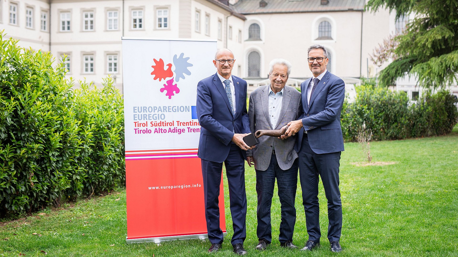 © Festival del giornalismo/Alena Klinger Il Capitano del Tirolo Anton Mattle (a sx) e il Presidente della Provincia autonoma di Bolzano Arno Kompatscher (a dx) insieme a Wendelin Weingartner, già Capitano del Tirolo, con in mano il premio da lui istituto, una scultura dell'artista Lois Anvidalfarei.