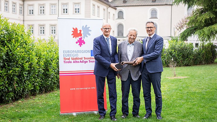 Die Landeshauptleute Anton Mattle (Tirol, links) und Arno Kompatscher (Südtirol, rechts) mit dem Stifter, dem Tiroler Landeshauptmann a. D. Wendelin Weingartner und dem Preis, einer Skulptur des Künstlers Lois Anvidalfarei. 