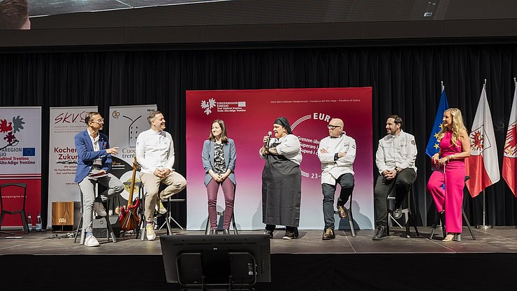 Mëisa turonda cun i presidënc dla lies di cueghes dl’Euregio: da man ciancia, l muderadëur Thomas Vonmetz, Patrick Jageregger (Südtirol), Madlen Hackl, Tina Marcelli, Stefano Goller (Trentin), Philipp Stohner (Tirol) y la muderadëura Karin Gschnitzer
