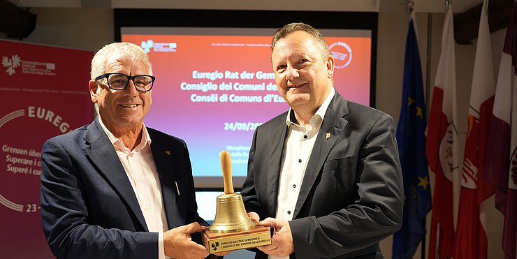 Symbolic handover of the session bell at the Euregio Council of Municipalities: (left) the incumbent President, Andreas Schatzer (South Tyrol), and his successor, Karl-Josef Schubert (Tyrol)