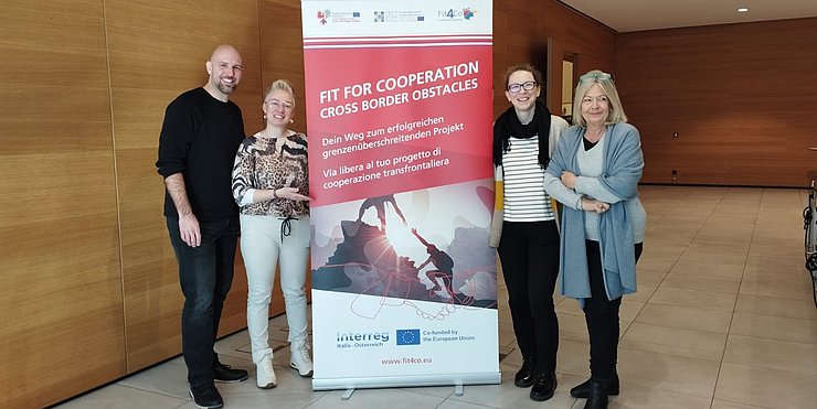 Projektpartner des Tandems "Euregio Guides" stehen vor dem Rollup "Fit4Co"