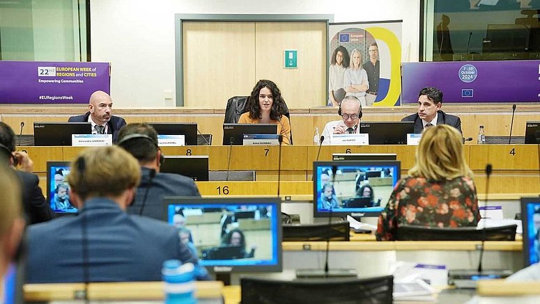 Konferenzgäste sprechen von der Bühne in einem überfüllten Raum