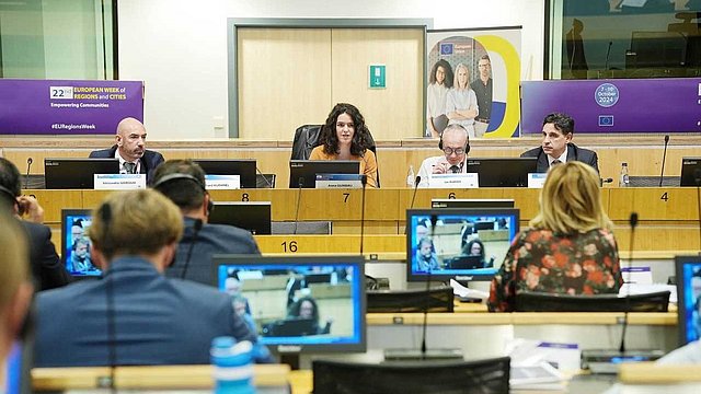 Konferenzgäste sprechen von der Bühne in einem überfüllten Raum