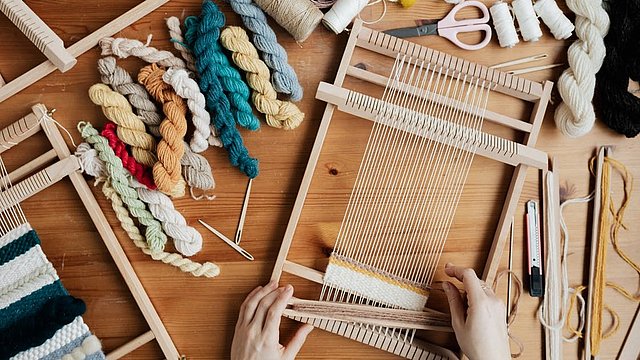 © Pexels/Karolina Grabowska Persona sta usando telaio per tessere in legno.