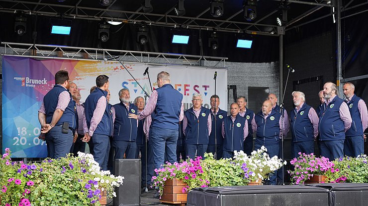 Esibizione del coro trentino Valbronzale sul palco della festa dell'Euregio a Brunico. 