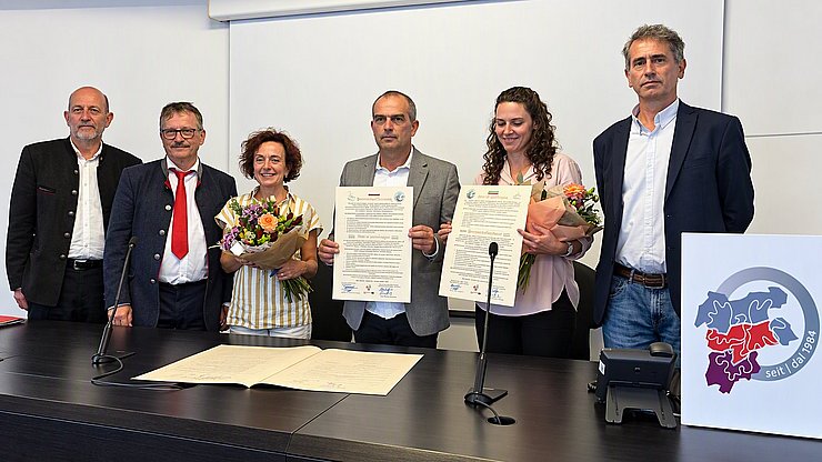 Stolz präsentieren beide Absolventenvereine die zweisprachigen Partnerschaftsurkunden nach  der feierlichen Unterzeichnung in San Michele. 