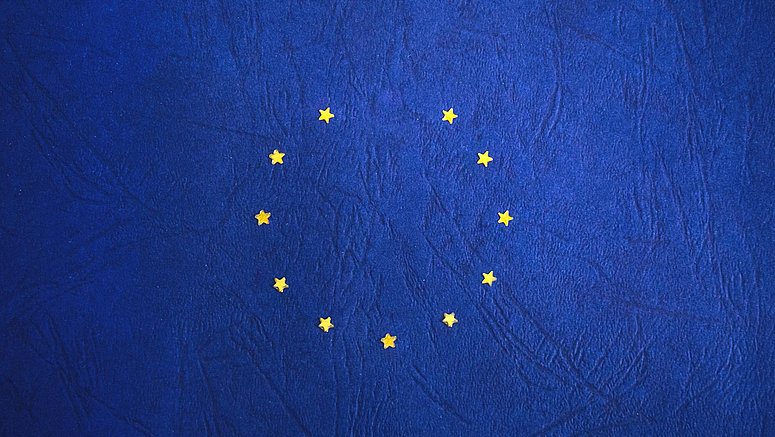 Dodici stelle dorate formano un cerchio su uno sfondo blu intenso, simboleggiando l'unità e l'armonia dell'Unione Europea.