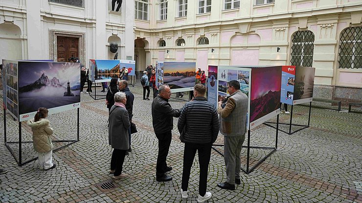 © LandTirol/DanijelJovanovic Die Wanderausstellung 10 Jahre Euregio-Kalender vor der Georgskapelle des Tiroler Landhauses