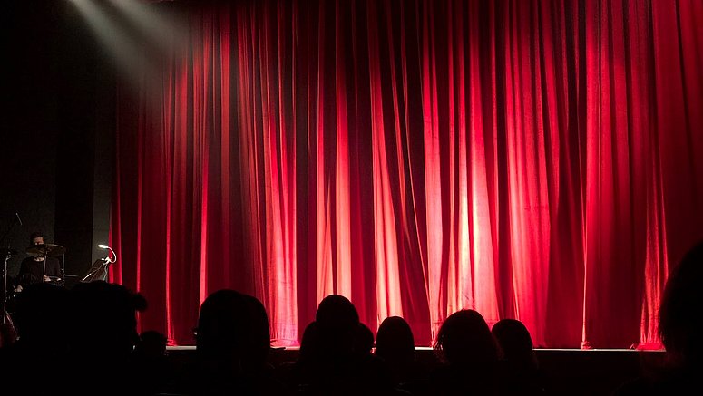 Theaterbühne mit Scheinwerferlicht und rotem Vorhang