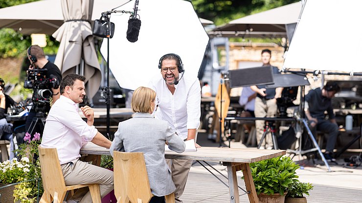© ORF Tirol Dreharbeiten zu "2 in Tirol": (von links) Das Moderatorenduo Sigi Fink und Kristina Sprenger im Gespräch mit Regisseur Titus Hollweg